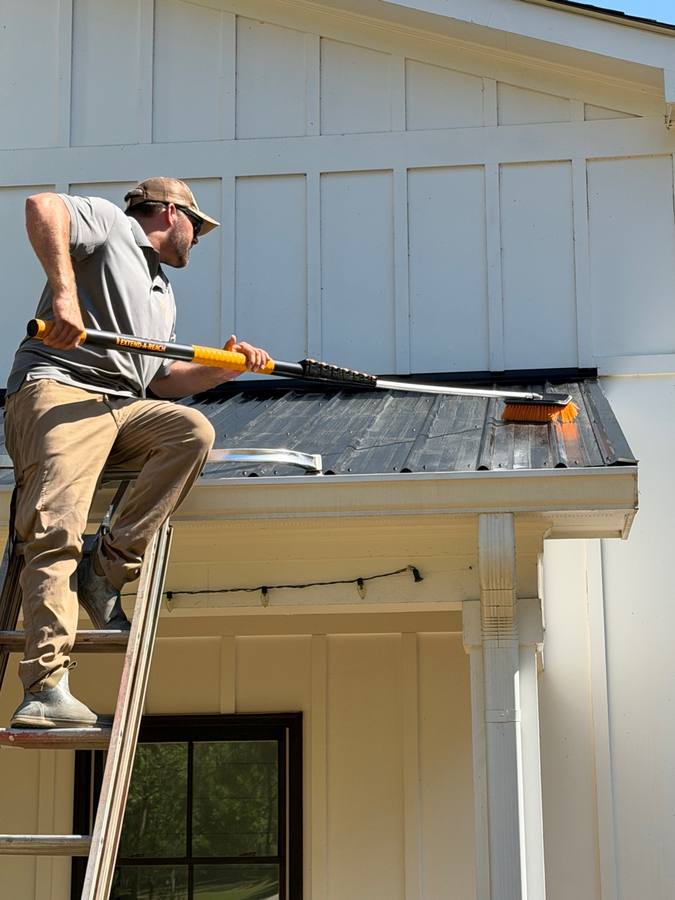 Close up of Trey cleaning gutters with extend-a-reach tool