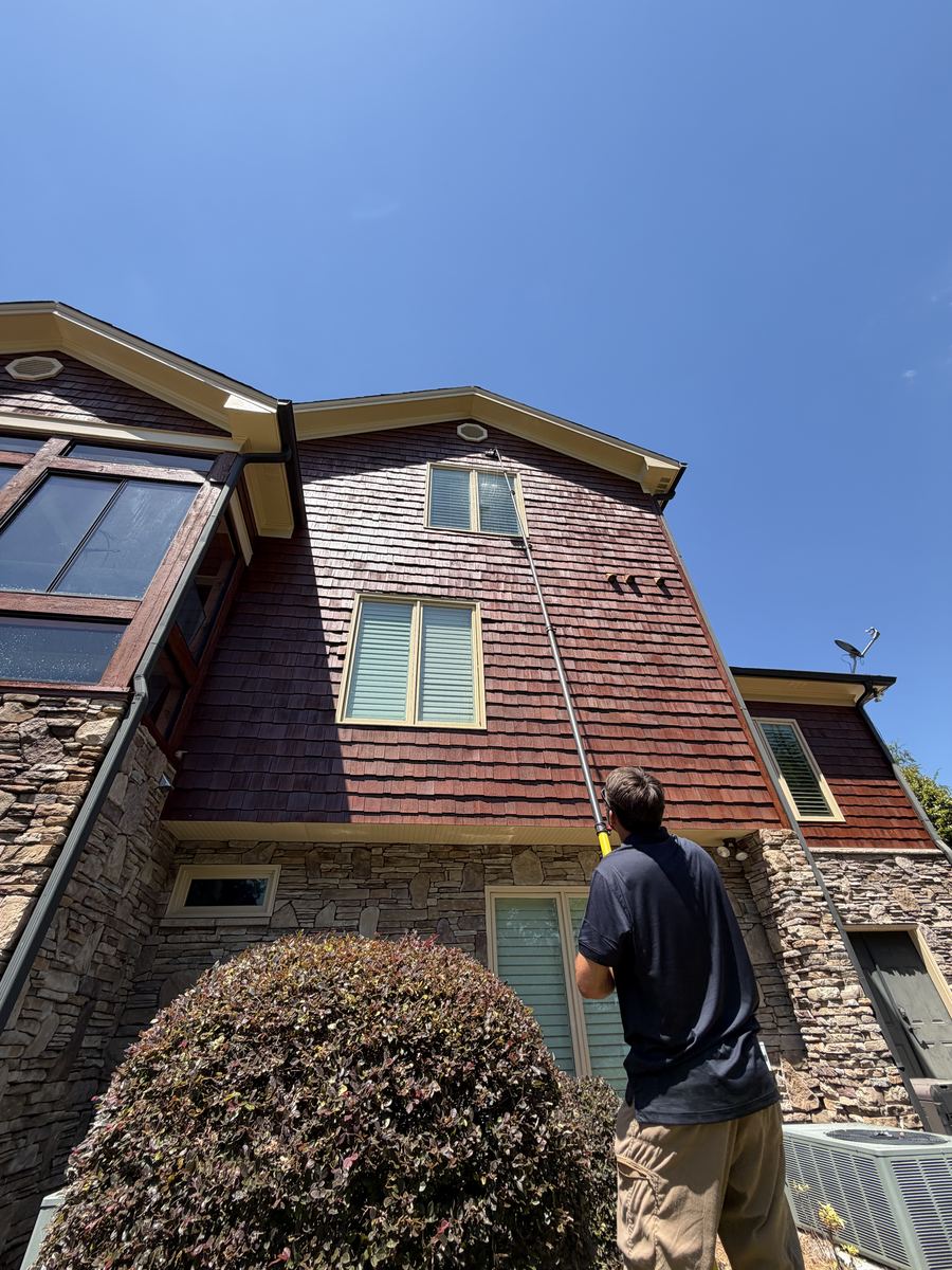 Close-up of water-fed pole window cleaning on multi-story home