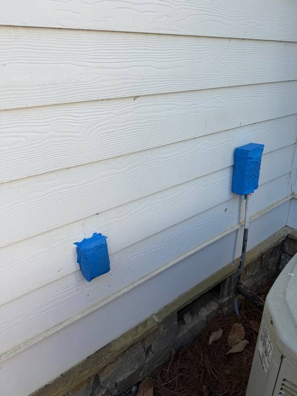 Electrical outlets taped off with blue tape before soft wash application