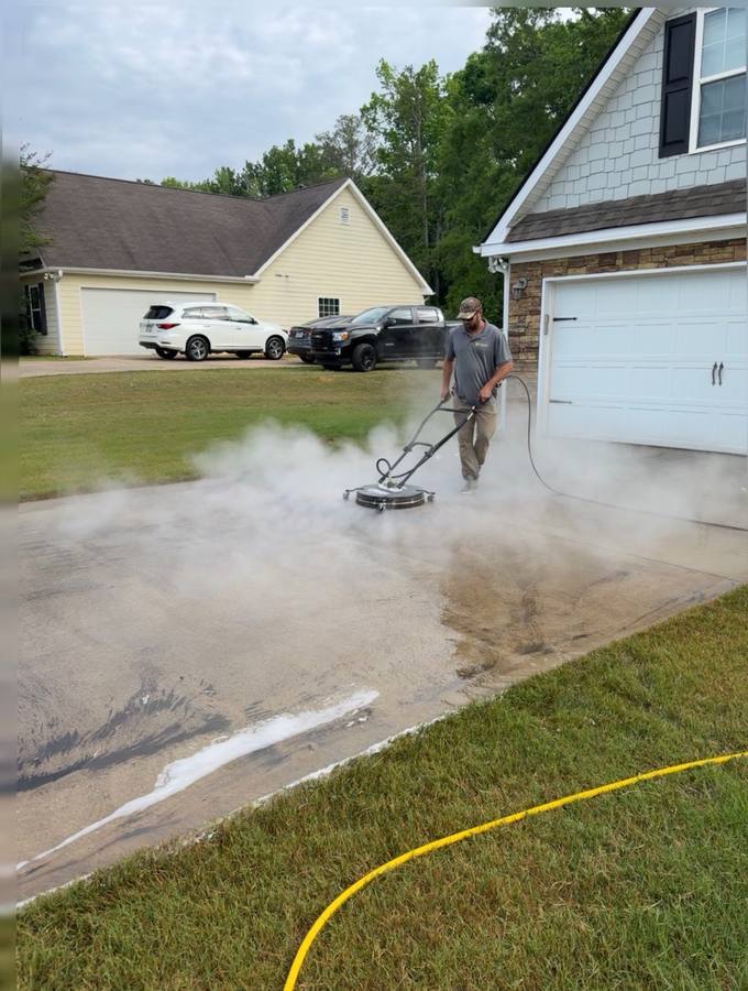 Piedmont Exterior hot water pressure washing removing oil stain from driveway — steam visible