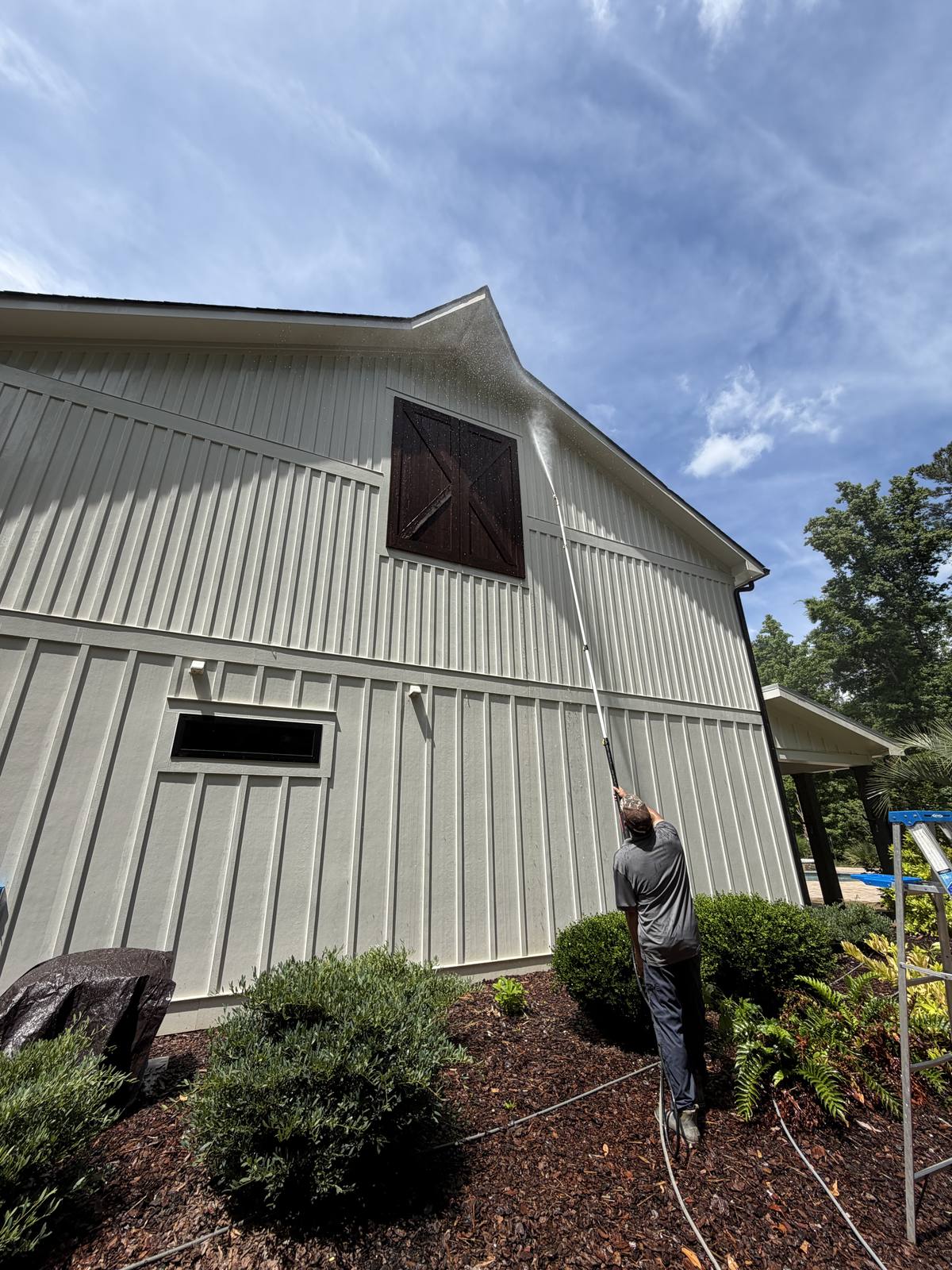 Piedmont Exterior technician pressure washing barn siding