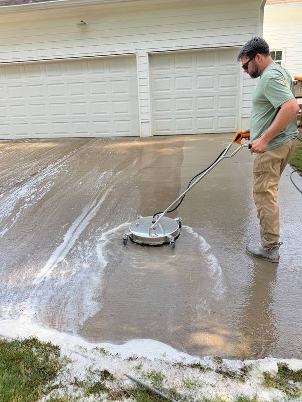 Trey operating professional surface cleaner on residential driveway